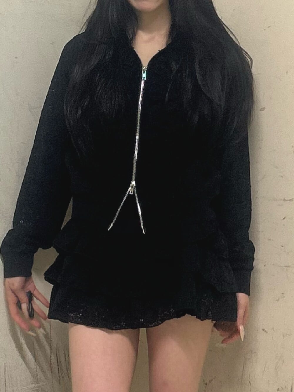 ブラック系のブーツ、ブラック系のスカート、ブラック系のパーカーを着用したレディースの春コーディネートの5枚目の写真