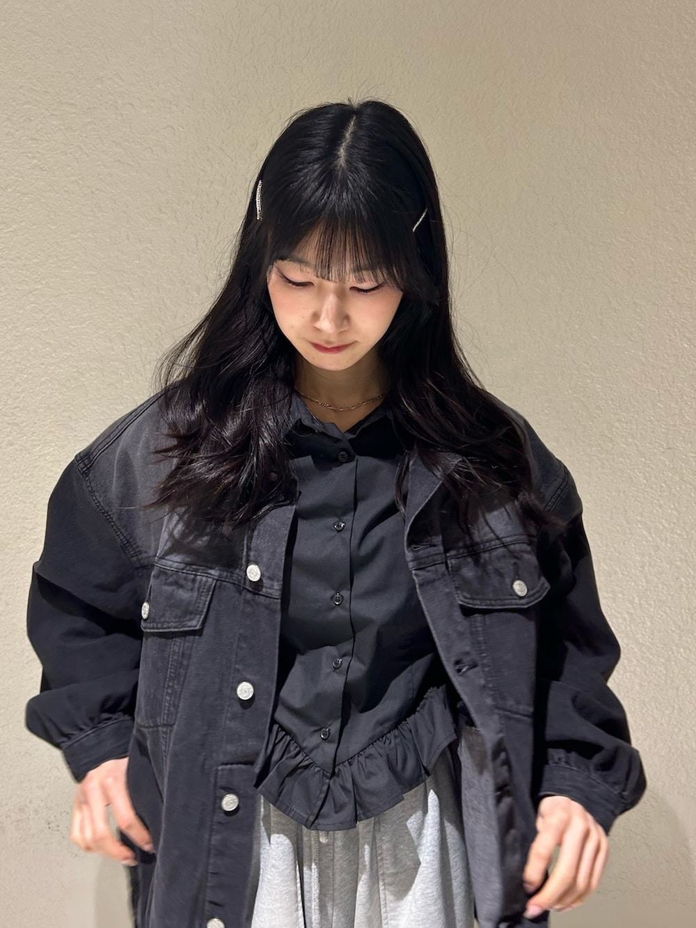 ブラック系のデニムジャケット、ブラック系のシャツ/ブラウス、グレー系のスウェットパンツを着用したレディースの春コーディネートの2枚目の写真