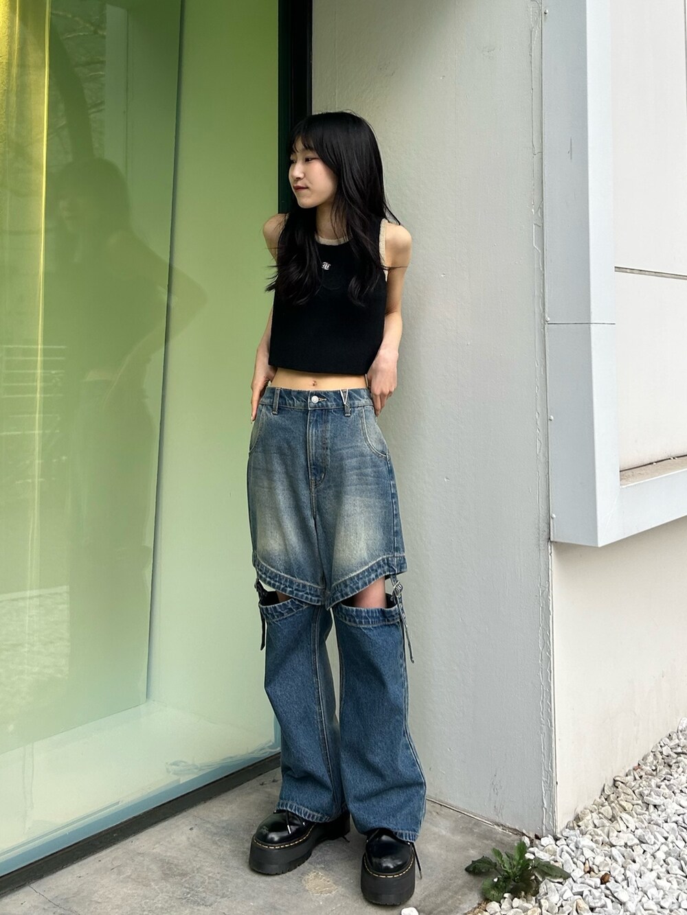 ブルー系のデニムパンツ、ブラック系のタンクトップを着用したレディースの春コーディネートの2枚目の写真