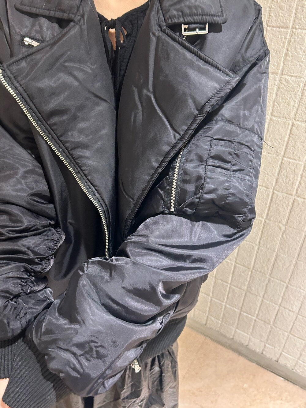 ブラック系のMA-1、ブラック系のニット/セーター、ブラック系のスカートを着用したレディースの冬コーディネートの5枚目の写真