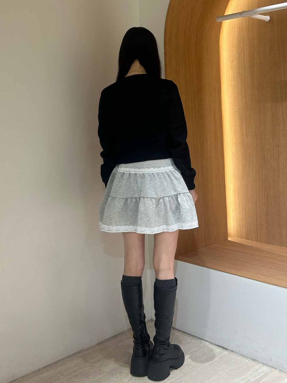 グレー系のワンピース、ブラック系のブーツ、ブラック系のカーディガン/ボレロを着用したレディースの春コーディネートの3枚目の写真