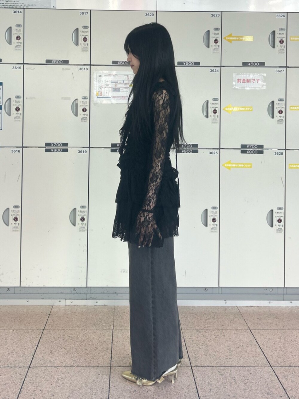 ゴールド系のパンプス、ブラック系のワンピース、ブラック系のデニムパンツを着用したレディースの冬コーディネートの2枚目の写真