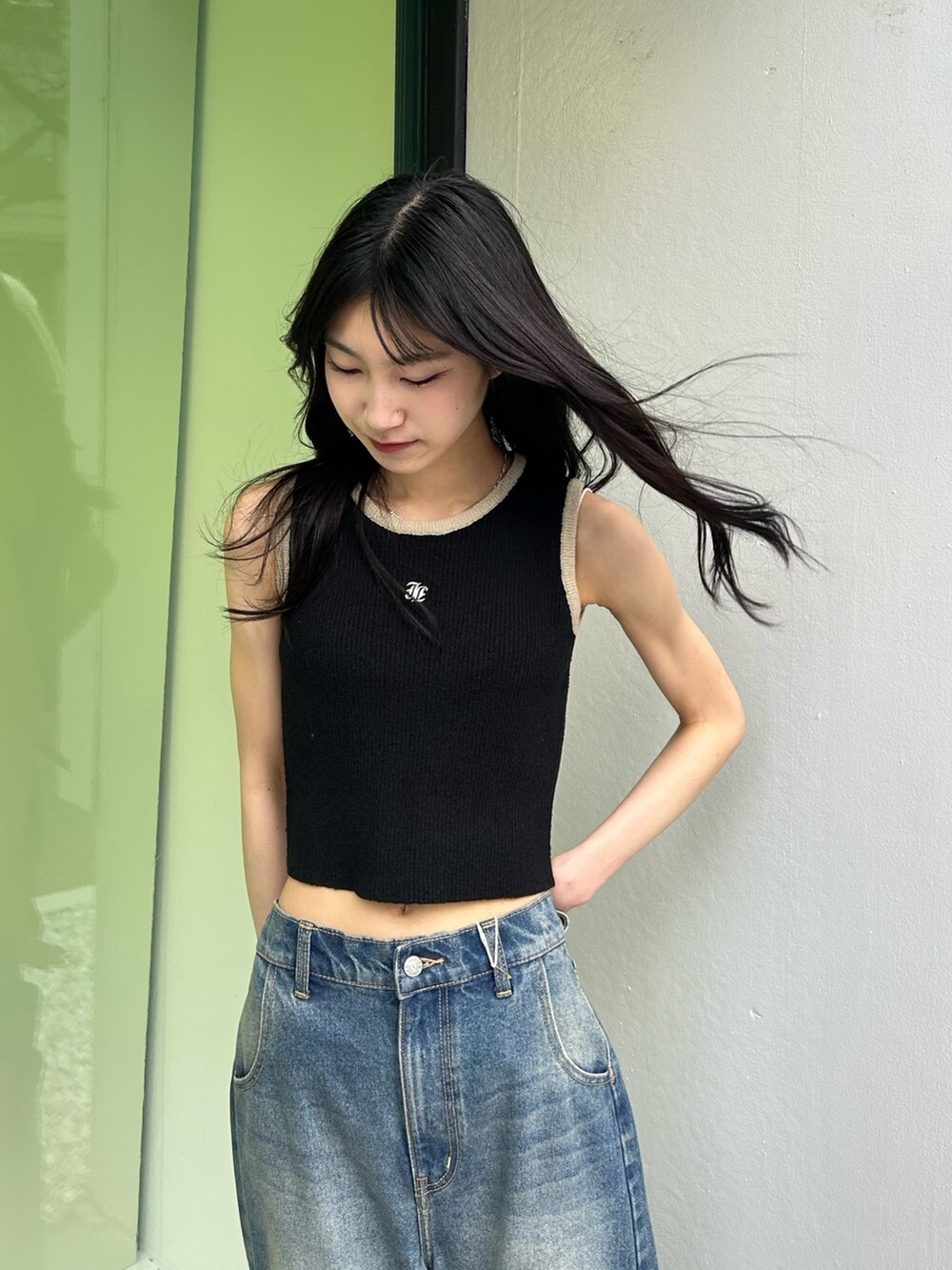 ブルー系のデニムパンツ、ブラック系のタンクトップを着用したレディースの春コーディネートの3枚目の写真