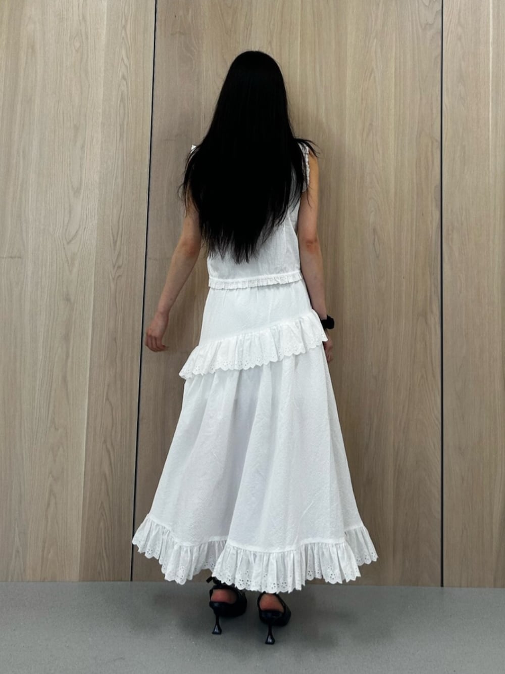 ブラック系のパンプス、ホワイト系のシャツ/ブラウス、ホワイト系のスカートを着用したレディースの夏コーディネートの3枚目の写真