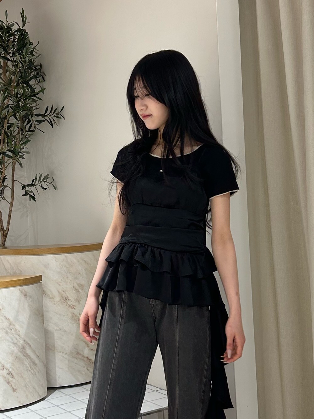 ブラック系のキャミソール、ブラック系のTシャツ/カットソー、ブラック系のデニムパンツを着用したレディースの春コーディネートの4枚目の写真