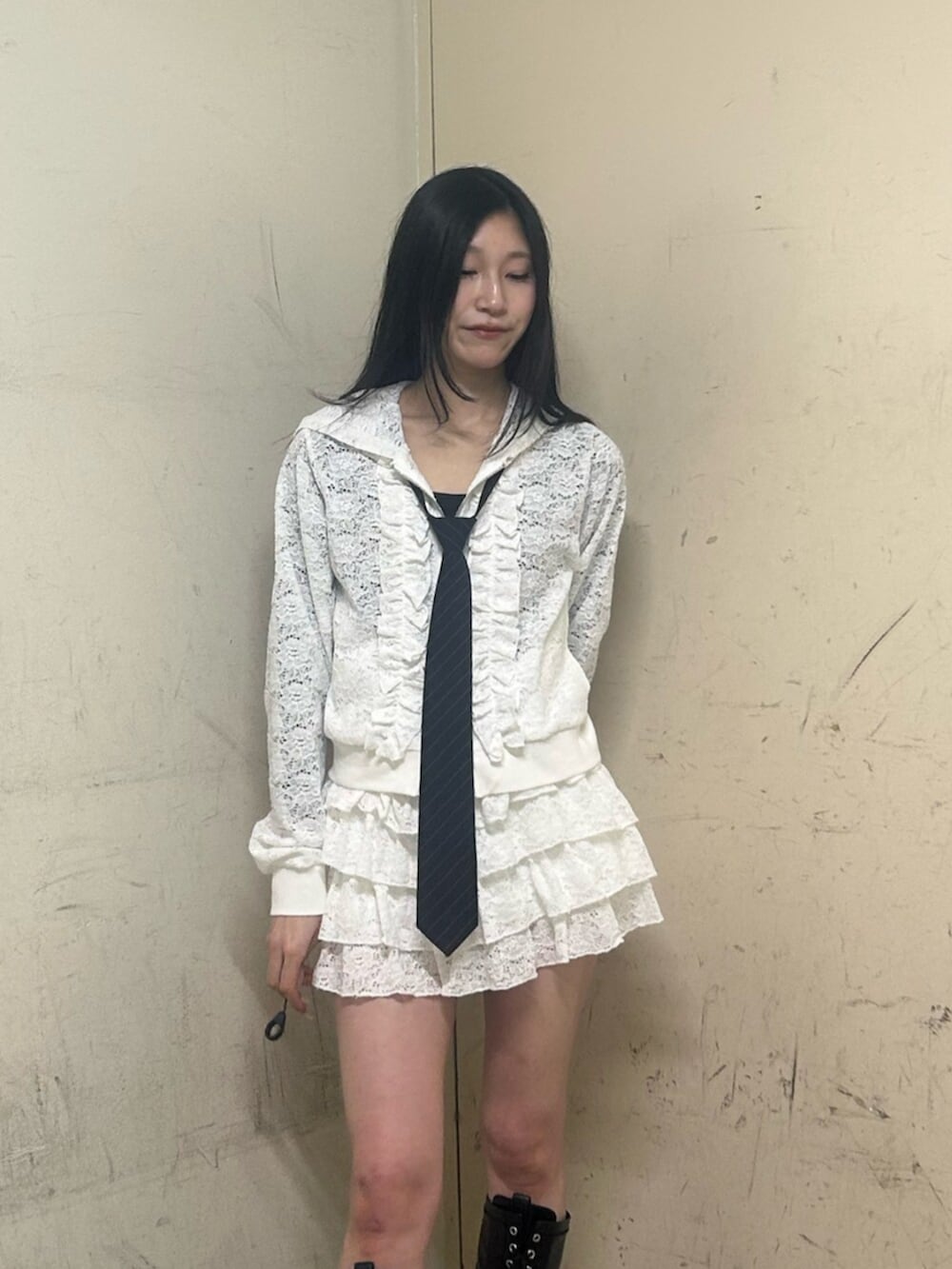 ブラック系のブーツ、ホワイト系のパーカー、ホワイト系のスカートを着用したレディースの春コーディネートの4枚目の写真