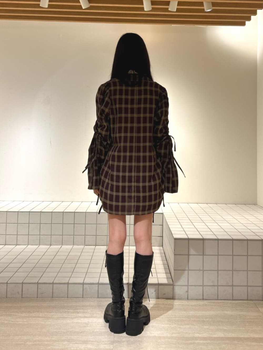 ホワイト系のキャミソール、ブラック系のブーツ、ブラック系のその他パンツを着用したレディースの秋コーディネートの3枚目の写真