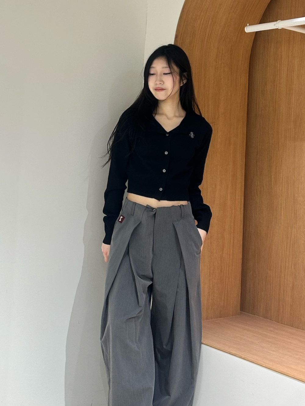 ブラック系のパンプス、グレー系のスラックス、ブラック系のカーディガン/ボレロを着用したレディースの春コーディネートの4枚目の写真