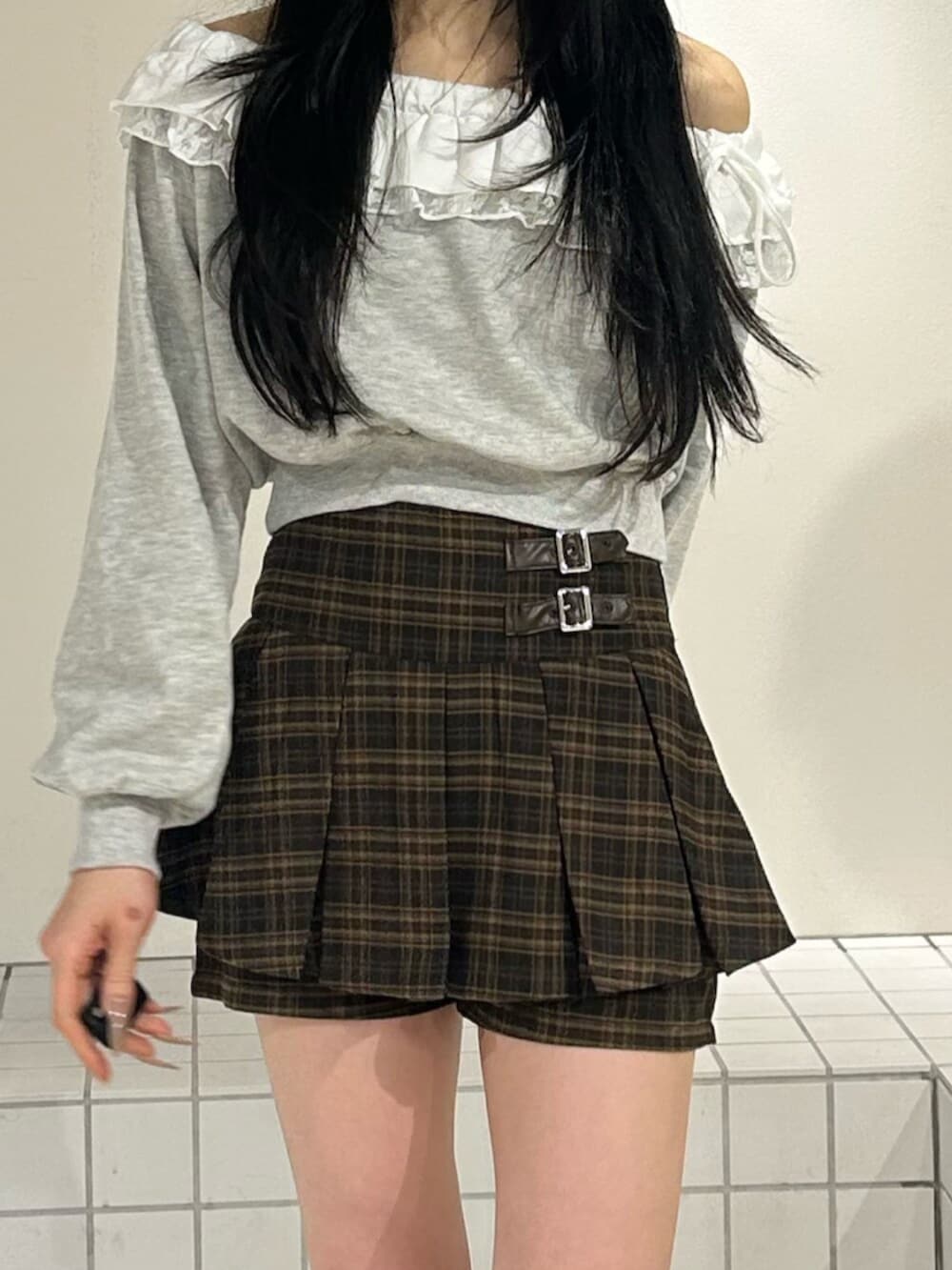 ブラウン系のスカート、グレー系のスウェット、ブラック系のブーツを着用したレディースの冬コーディネートの5枚目の写真