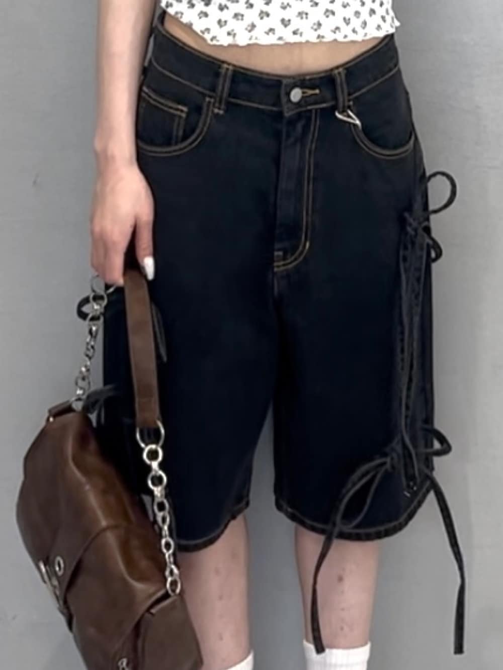 ブラック系のデニムパンツ、ホワイト系のアンサンブル、ホワイト系のスニーカーを着用したレディースの春コーディネートの6枚目の写真