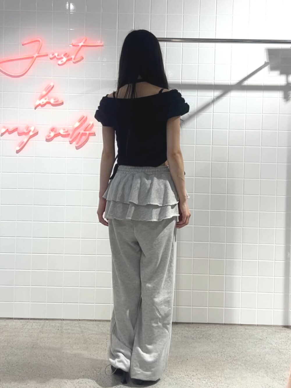 ブラック系のパンプス、グレー系のスウェットパンツ、ブラック系のTシャツ/カットソーを着用したレディースの秋コーディネートの3枚目の写真