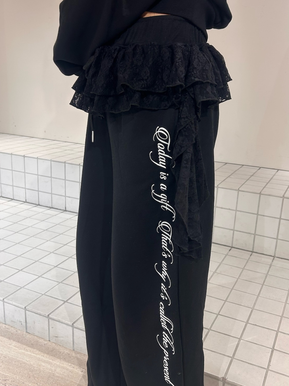 ブラック系のスウェット、ブラック系のスウェットパンツ、ブラック系のパンプスを着用したレディースの冬コーディネートの6枚目の写真