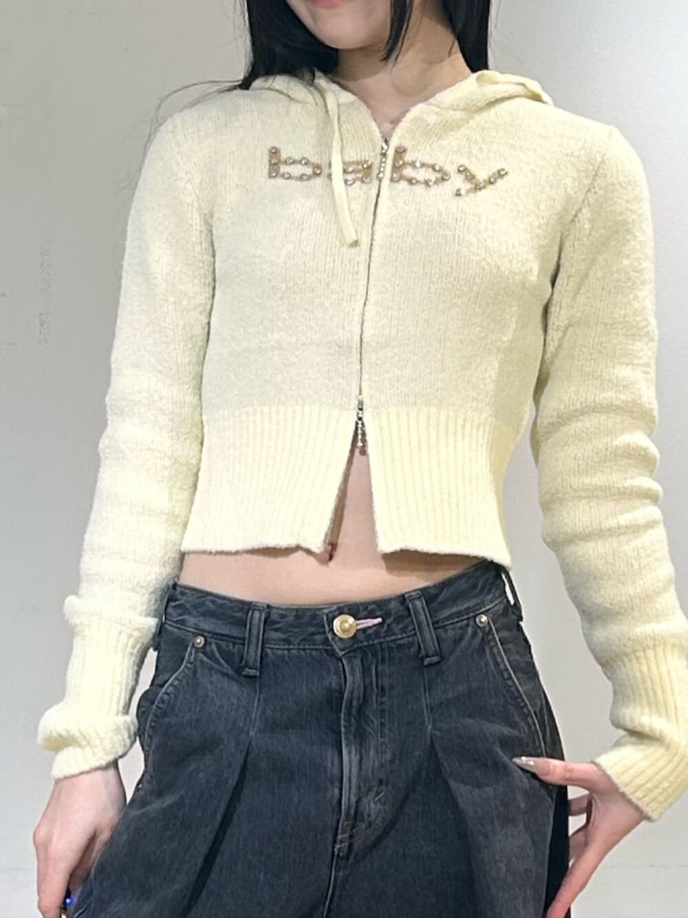 ブラック系のパンプス、ブルー系のデニムパンツ、イエロー系のパーカーを着用したレディースの冬コーディネートの5枚目の写真