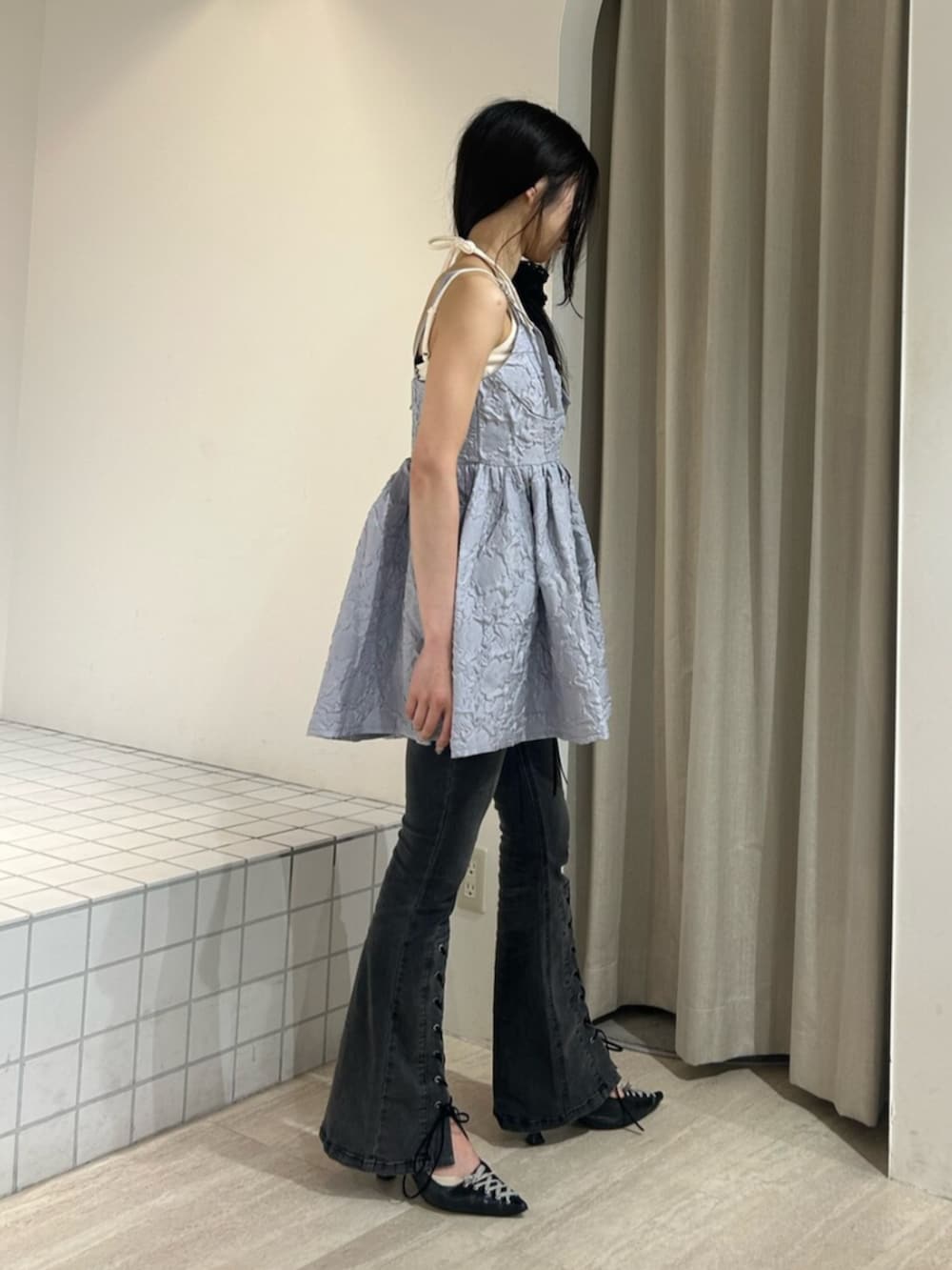 ブラック系のパンプス、ホワイト系のキャミソール、ブラック系のデニムパンツを着用したレディースの夏コーディネートの2枚目の写真