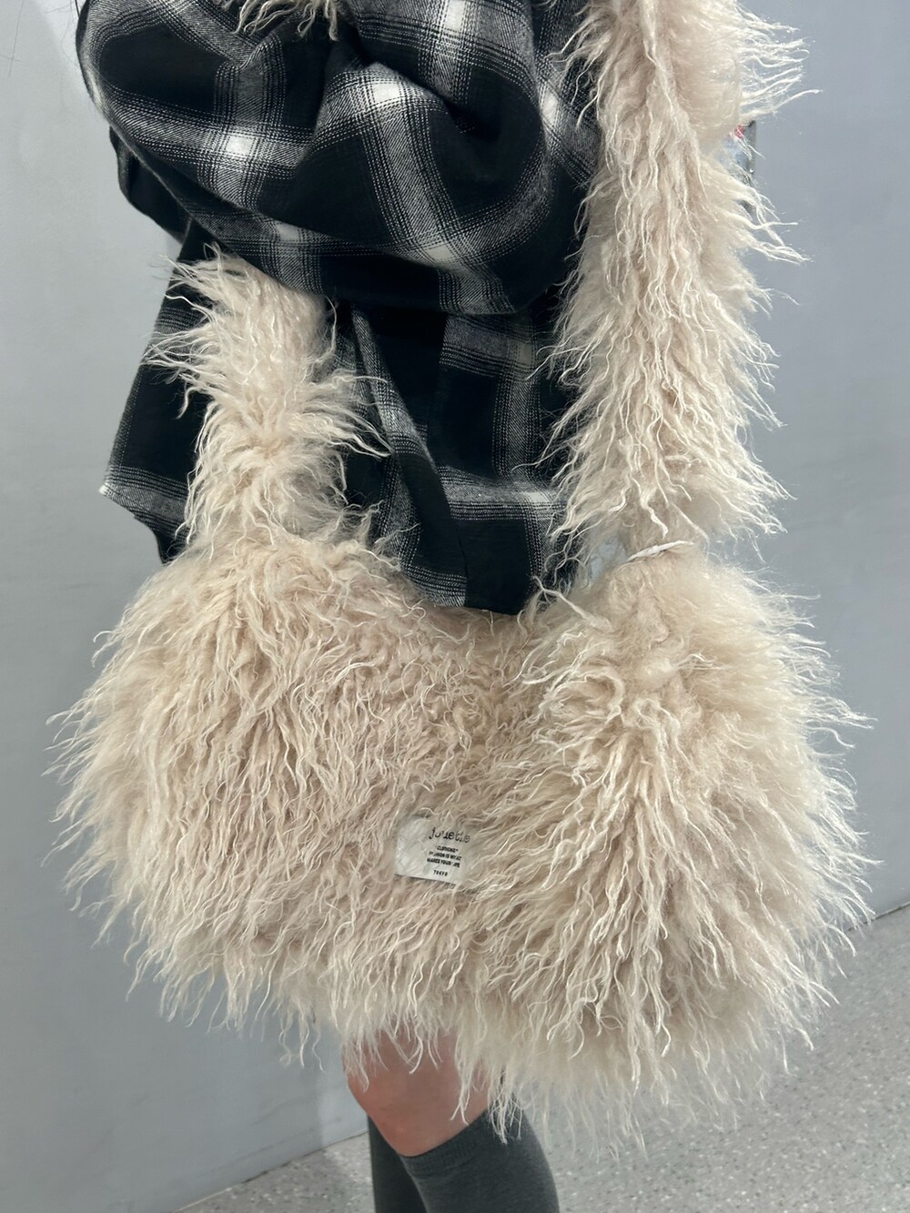 ホワイト系のショルダーバッグ、ベージュ系のブーツ、ブラウン系のスカートを着用したレディースの秋コーディネートの8枚目の写真