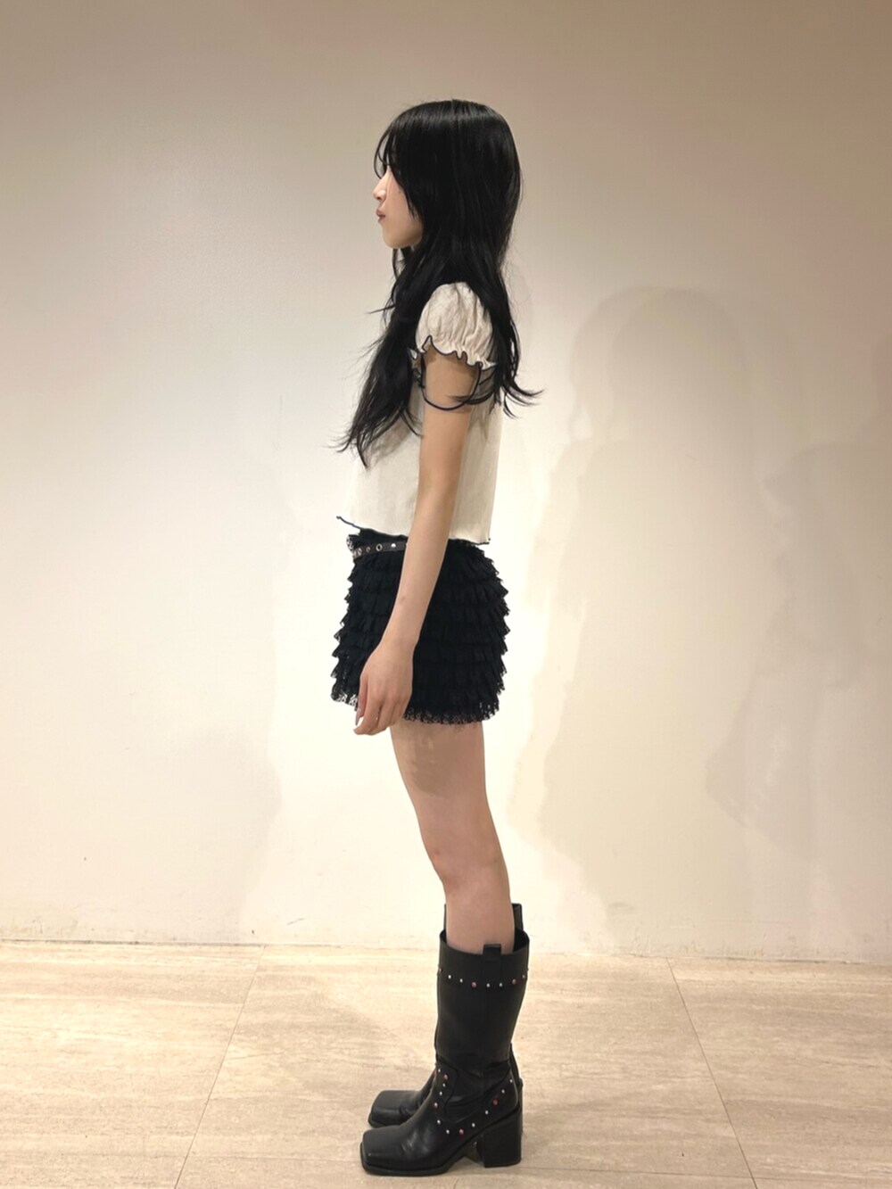 ブラック系のその他パンツ、ブラック系のブーツ、ホワイト系のポロシャツを着用したレディースの春コーディネートの2枚目の写真