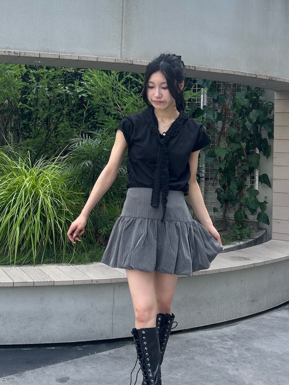 グレー系のスカート、ブラック系のTシャツ/カットソー、ブラック系のブーツを着用したレディースの夏コーディネートの4枚目の写真