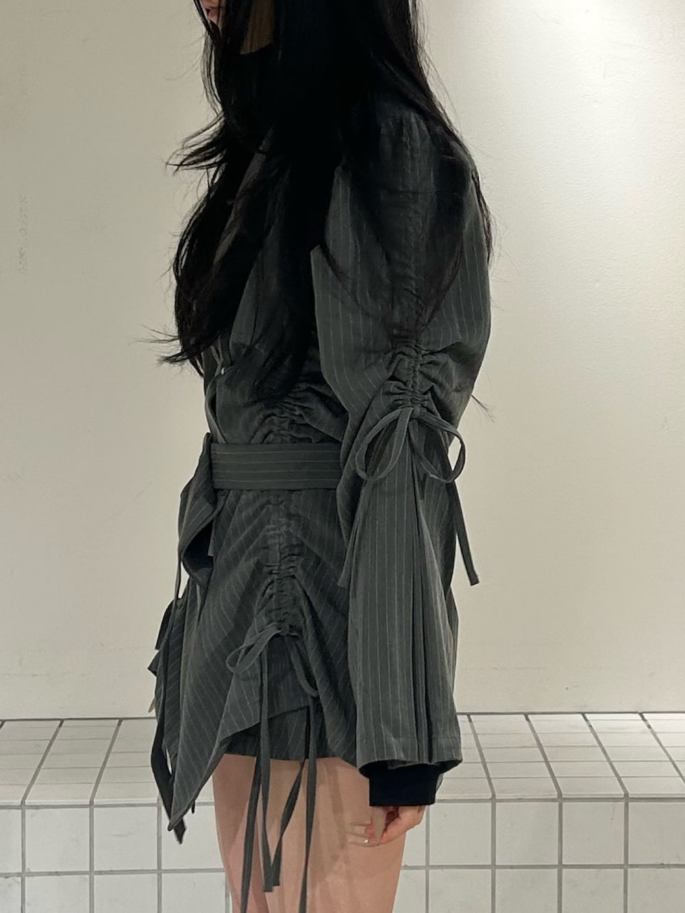 ブラック系のブーツ、グレー系のテーラードジャケット、ブラック系のニット/セーターを着用したレディースの冬コーディネートの6枚目の写真