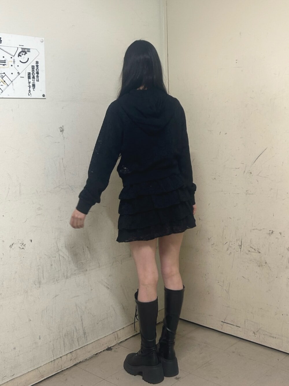 ブラック系のブーツ、ブラック系のスカート、ブラック系のパーカーを着用したレディースの春コーディネートの3枚目の写真