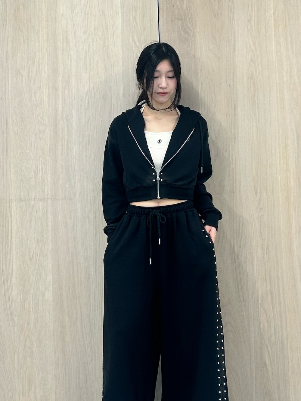 ブラック系のパーカー、ブラック系のスウェットパンツ、ブラック系のパンプスを着用したレディースの春コーディネートの4枚目の写真