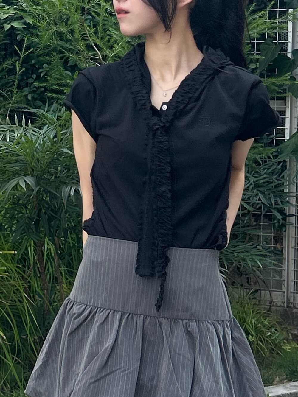 グレー系のスカート、ブラック系のTシャツ/カットソー、ブラック系のブーツを着用したレディースの夏コーディネートの5枚目の写真