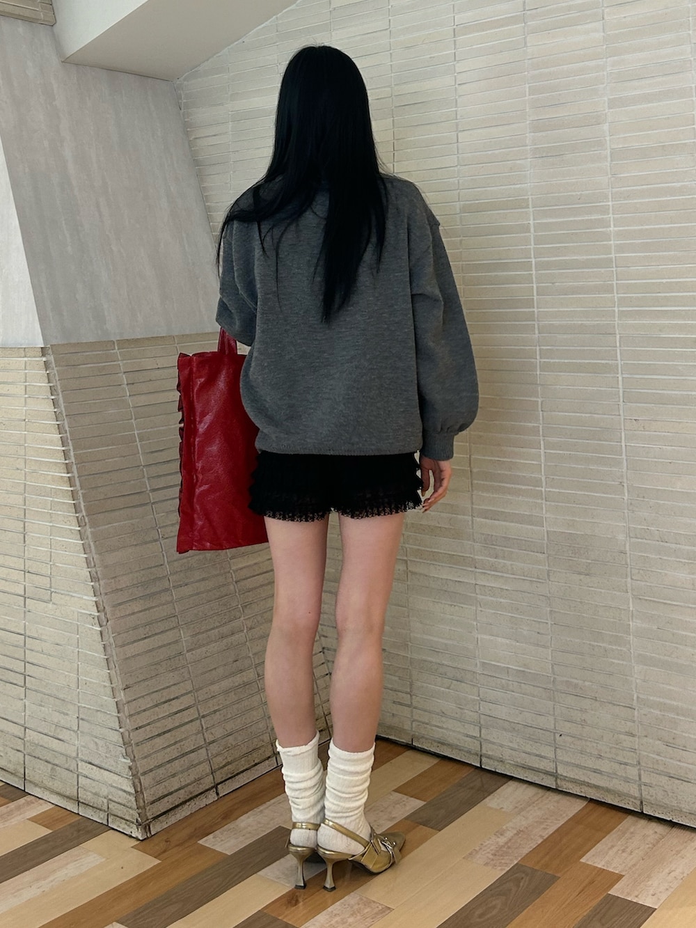 ゴールド系のパンプス、ブラック系のその他パンツ、レッド系のトートバッグを着用したレディースの冬コーディネートの3枚目の写真