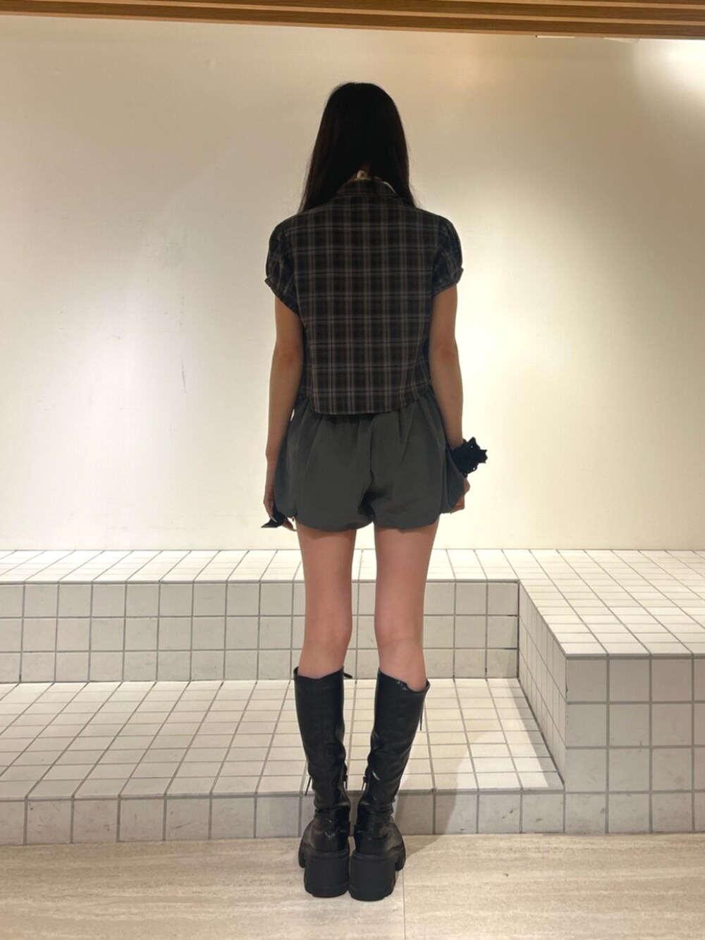 ホワイト系のキャミソール、ブラック系のブーツ、ブラウン系のシャツ/ブラウスを着用したレディースの秋コーディネートの3枚目の写真