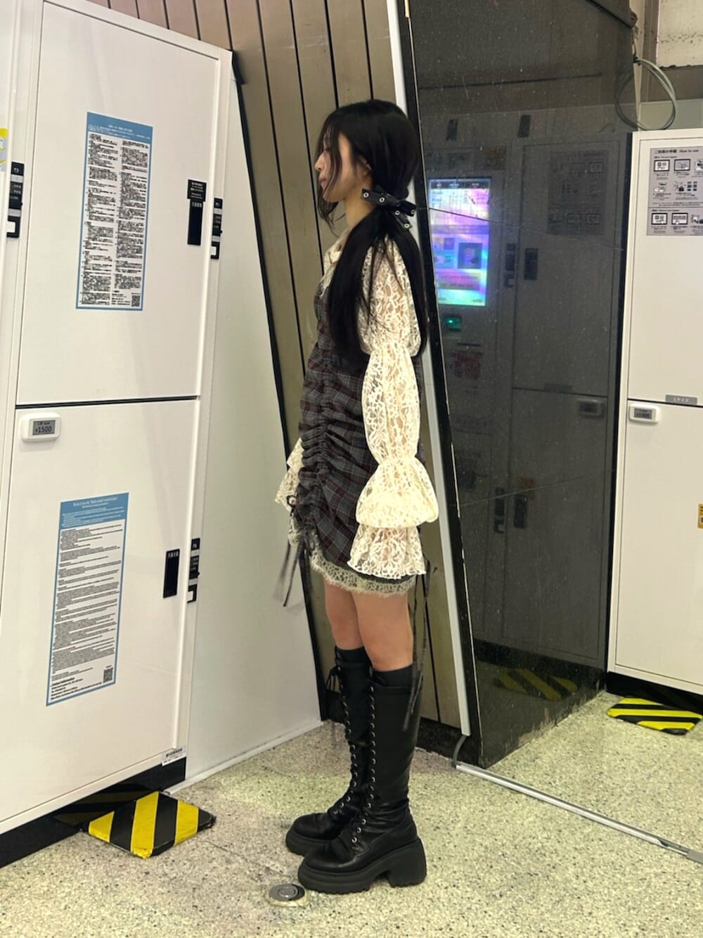 ブラック系のブーツ、ホワイト系のカーディガン/ボレロ、ブラック系のワンピースを着用したレディースの春コーディネートの3枚目の写真