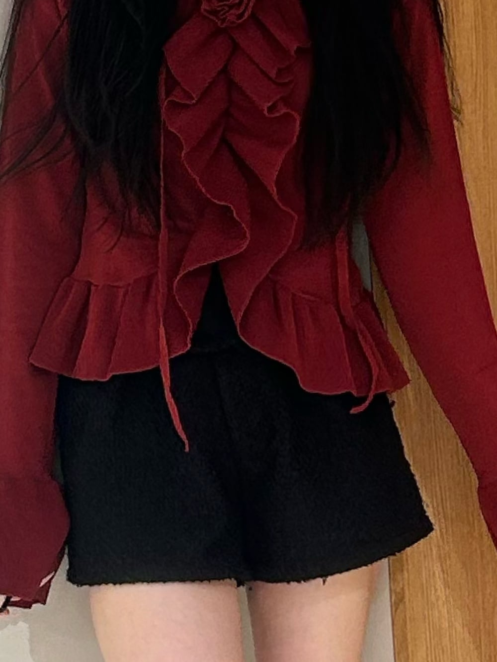 レッド系のニット/セーター、ブラック系のその他パンツ、ブラック系のブーツを着用したレディースの春コーディネートの6枚目の写真