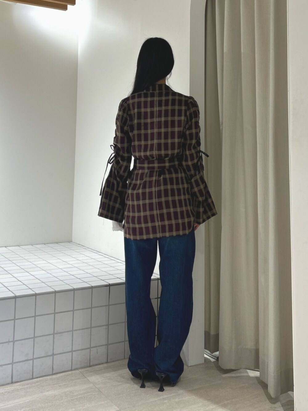 ブラック系のパンプス、レッド系のワンピース、ブルー系のデニムパンツを着用したレディースの秋コーディネートの3枚目の写真