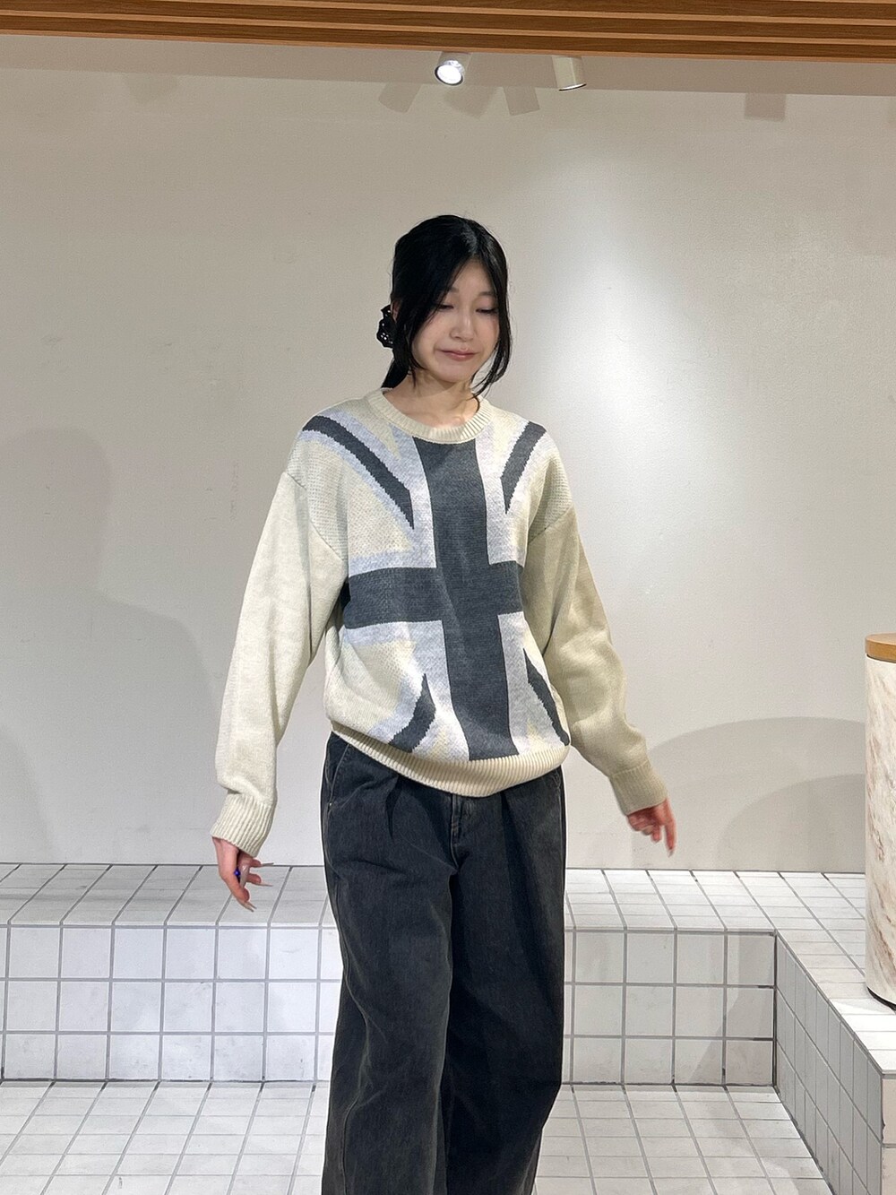 ホワイト系のニット/セーター、ブルー系のデニムパンツ、ブラック系のパンプスを着用したレディースの冬コーディネートの4枚目の写真