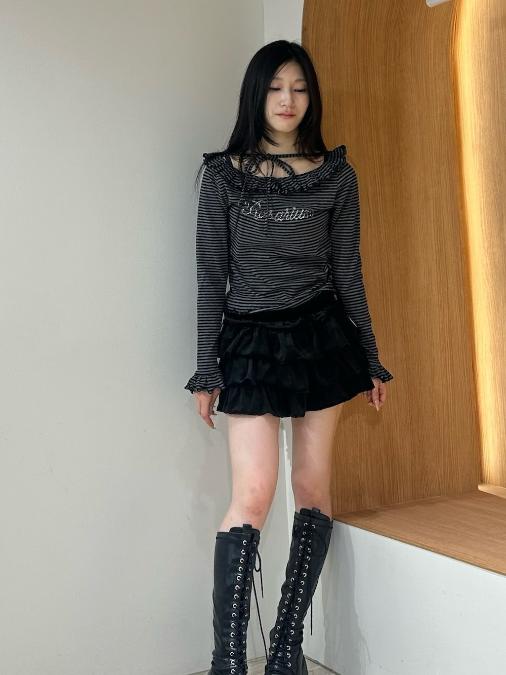 ブラック系のスカート、ブラック系のブーツ、ブラック系のTシャツ/カットソーを着用したレディースの秋コーディネートの4枚目の写真