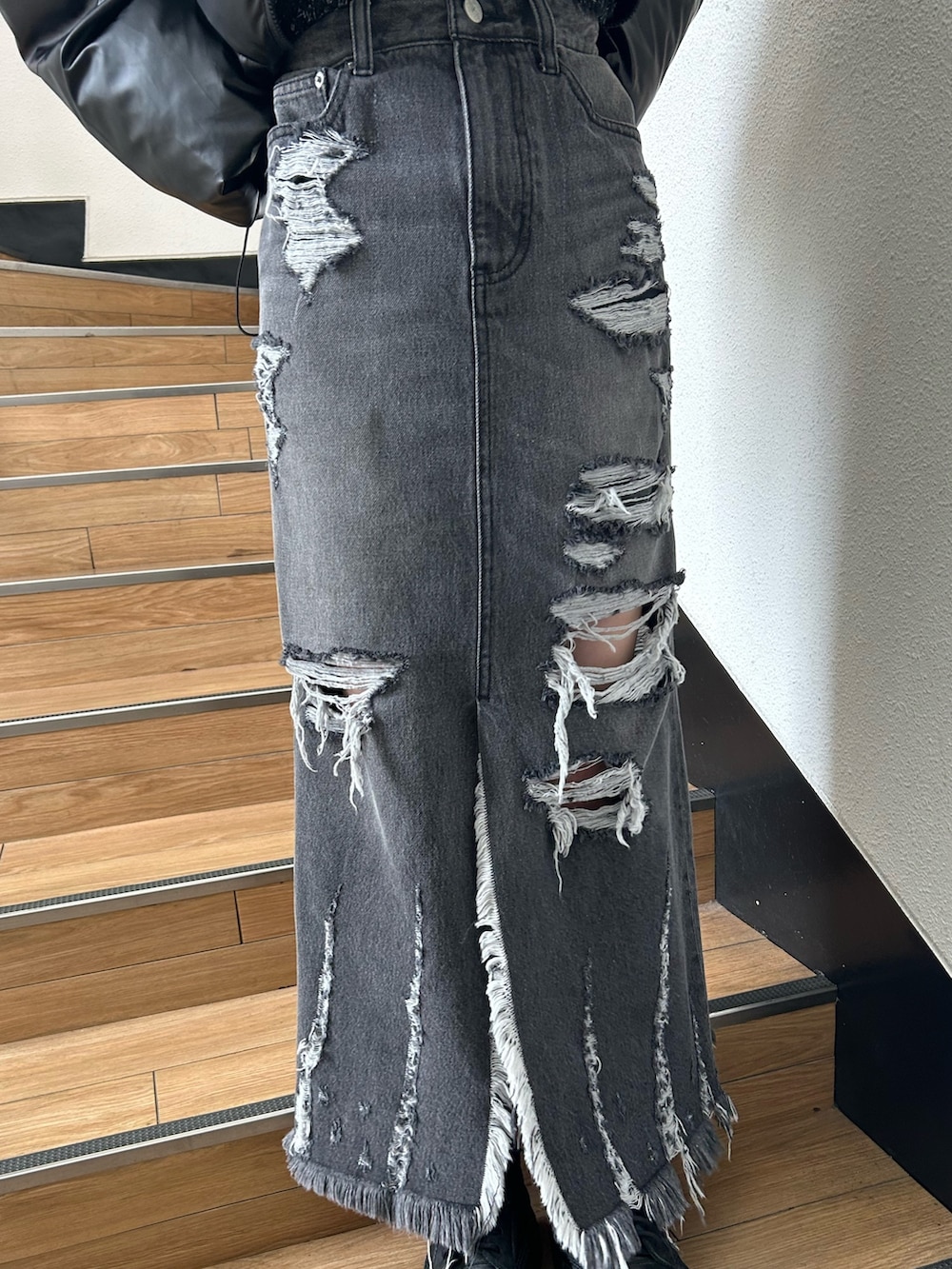 ブラック系のダウンジャケット/コート、ブラック系のニット/セーター、ブラック系のデニムスカートを着用したレディースの冬コーディネートの6枚目の写真