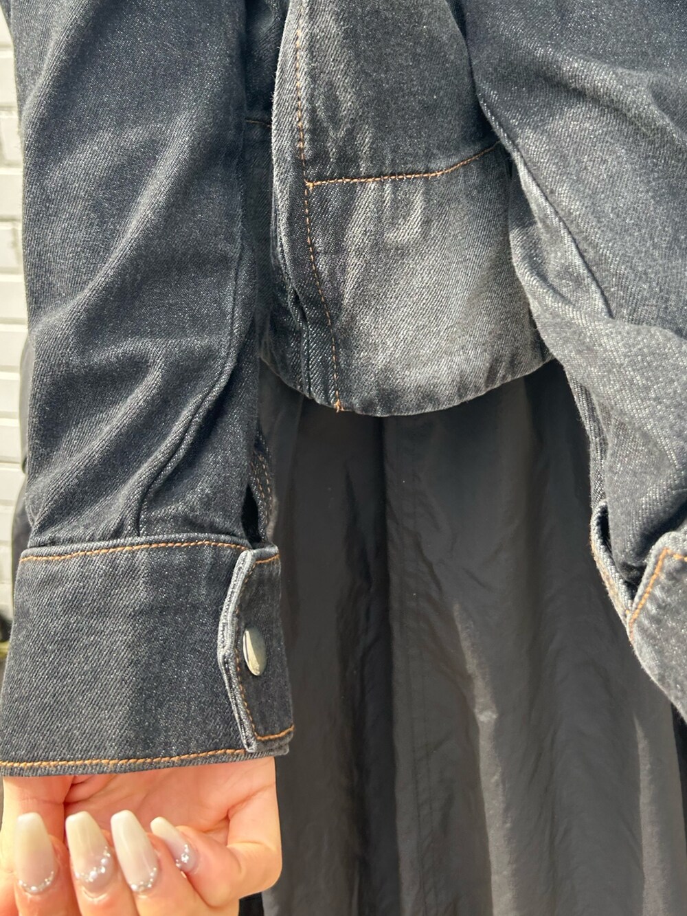 ブラック系のデニムジャケット、ブラック系のスカートを着用したレディースの冬コーディネートの5枚目の写真