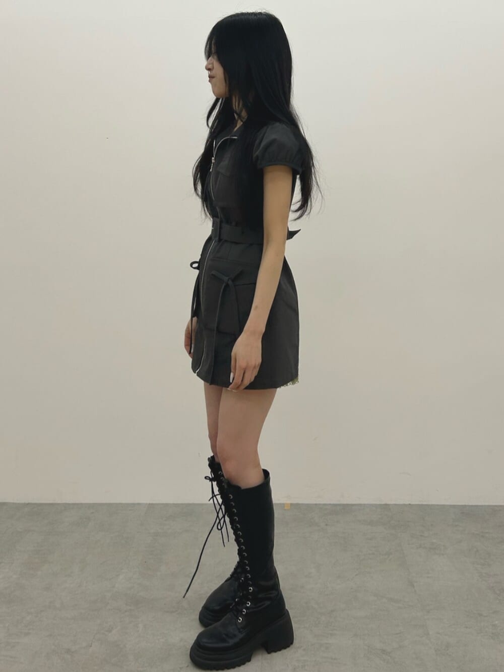 ブラック系のブーツ、ブラック系のワンピースを着用したレディースの春コーディネートの2枚目の写真