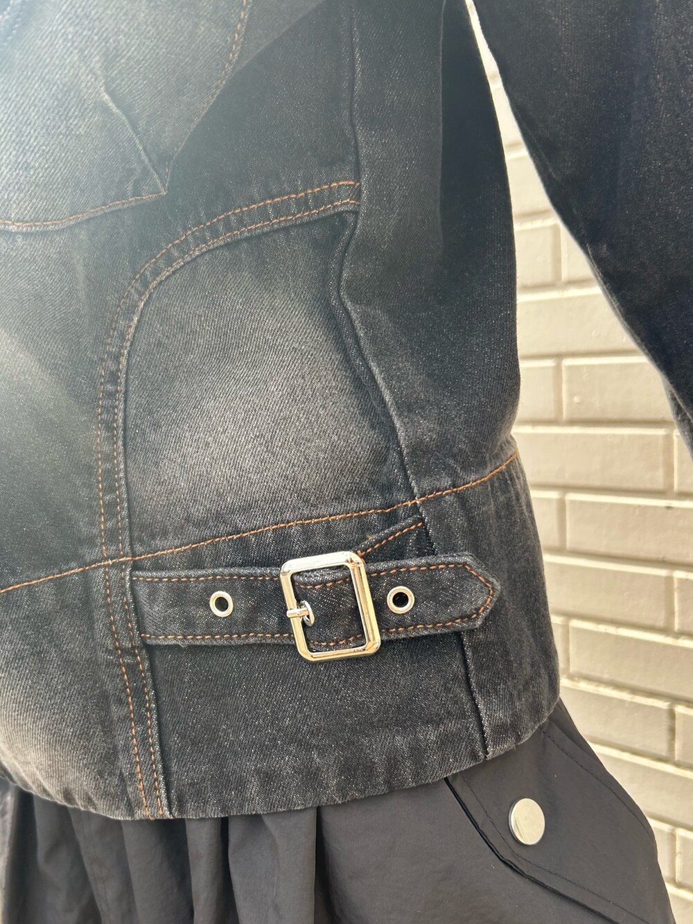 ブラック系のデニムジャケット、ブラック系のスカートを着用したレディースの冬コーディネートの6枚目の写真