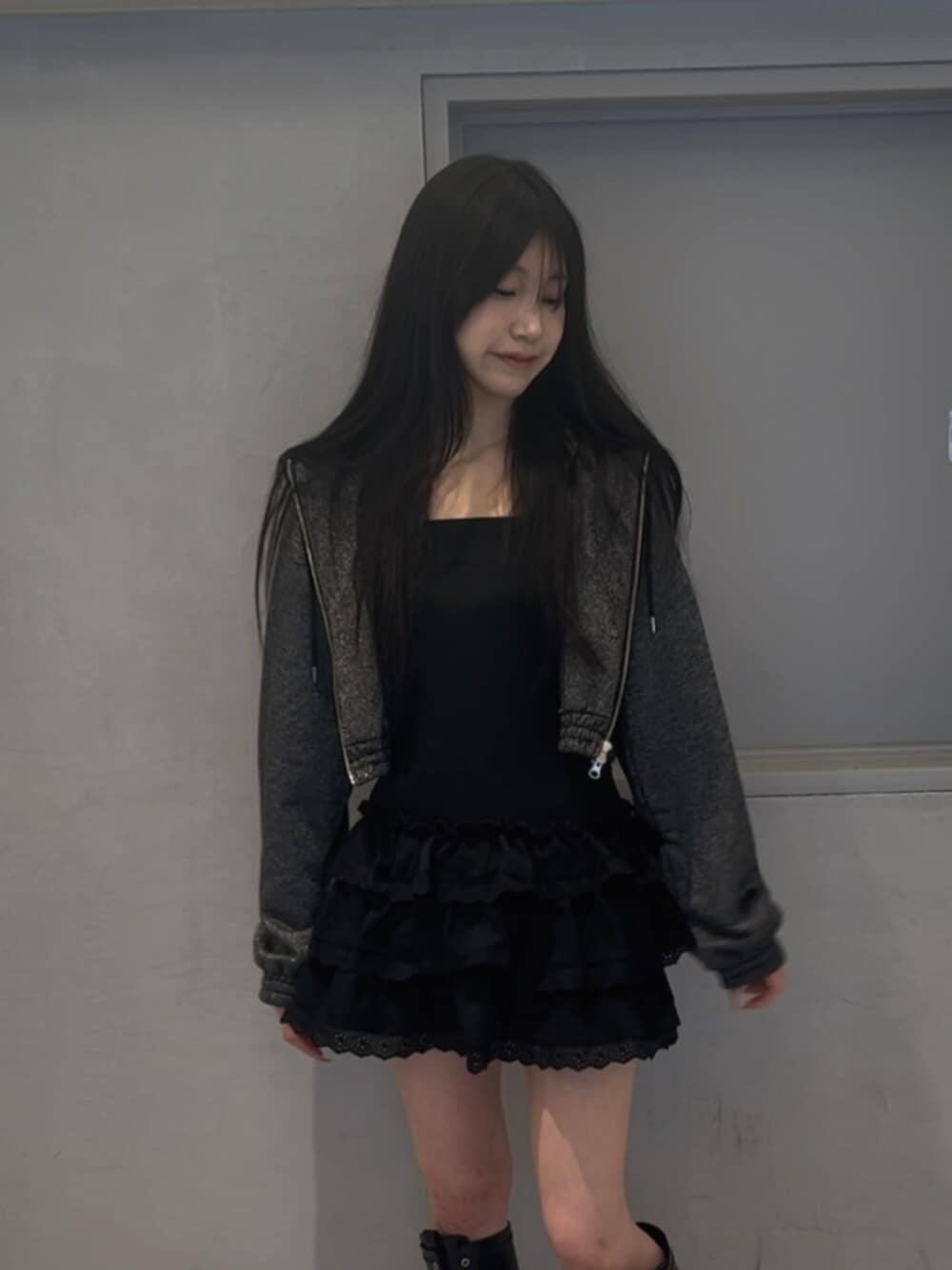 ブラック系のパーカー、ブラック系のワンピース、ブラック系のブーツを着用したレディースの春コーディネートの4枚目の写真