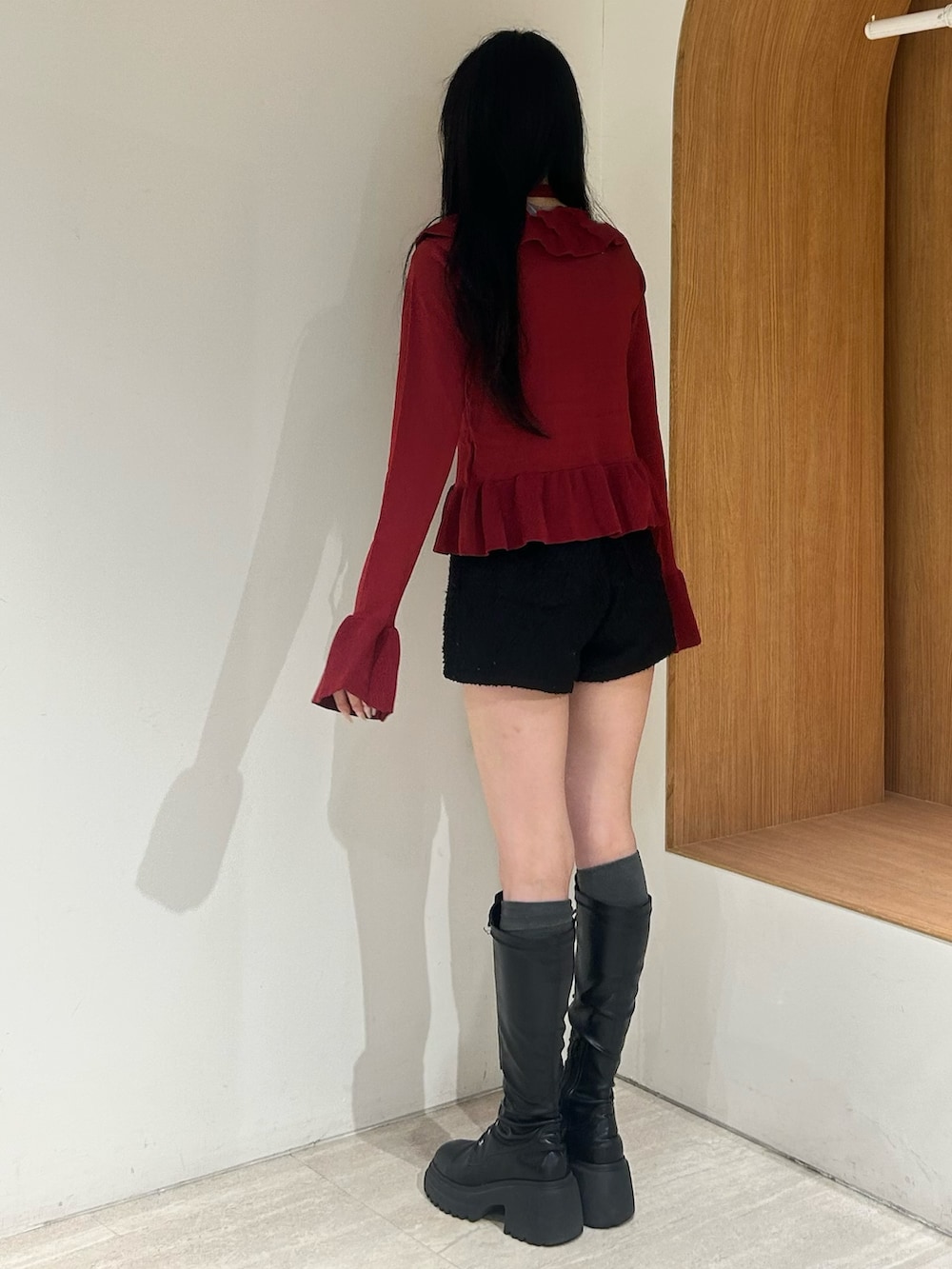 レッド系のニット/セーター、ブラック系のその他パンツ、ブラック系のブーツを着用したレディースの春コーディネートの3枚目の写真