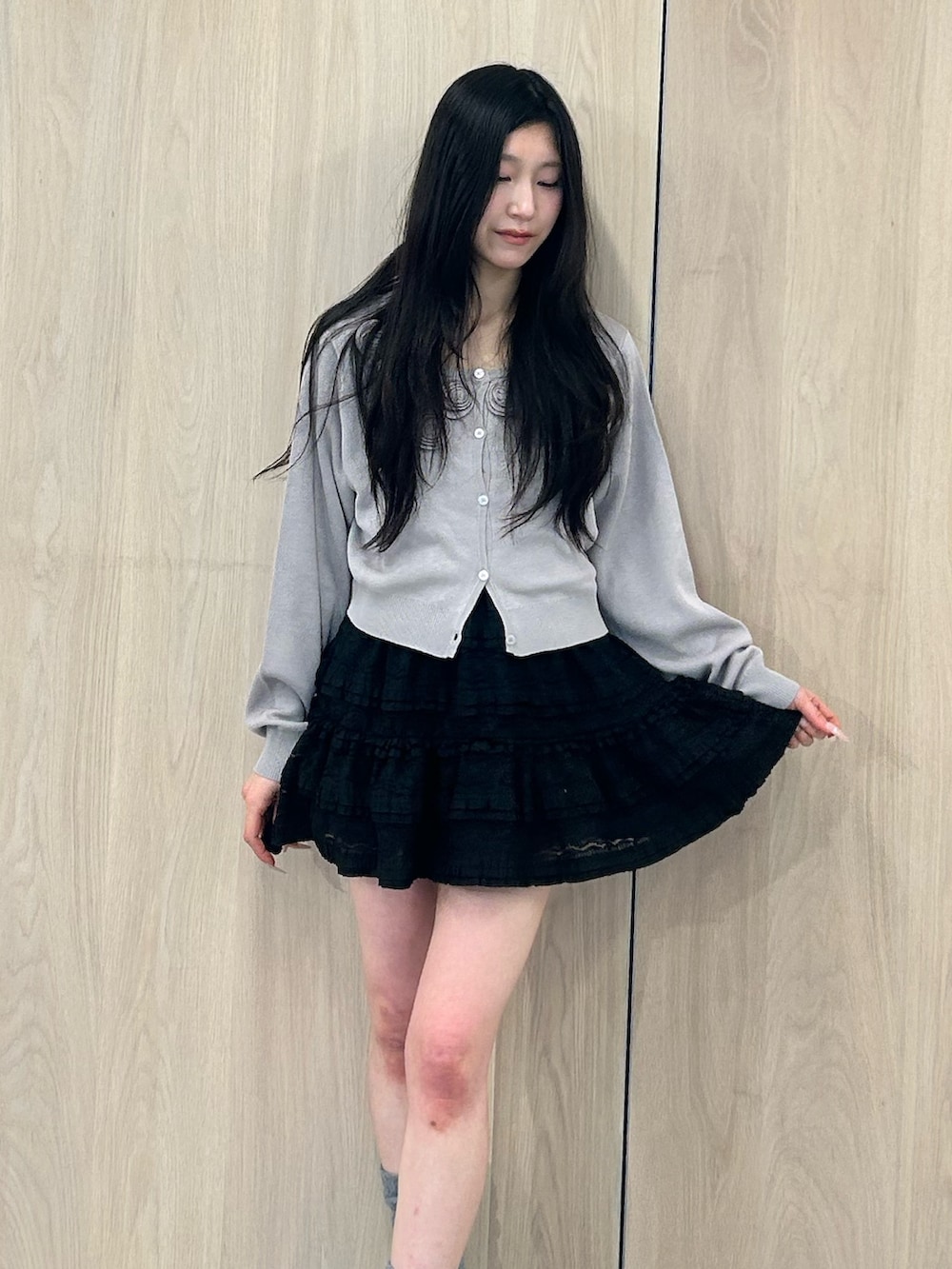 グレー系のニット/セーター、ブラック系のワンピース、ブラック系のパンプスを着用したレディースの春コーディネートの4枚目の写真