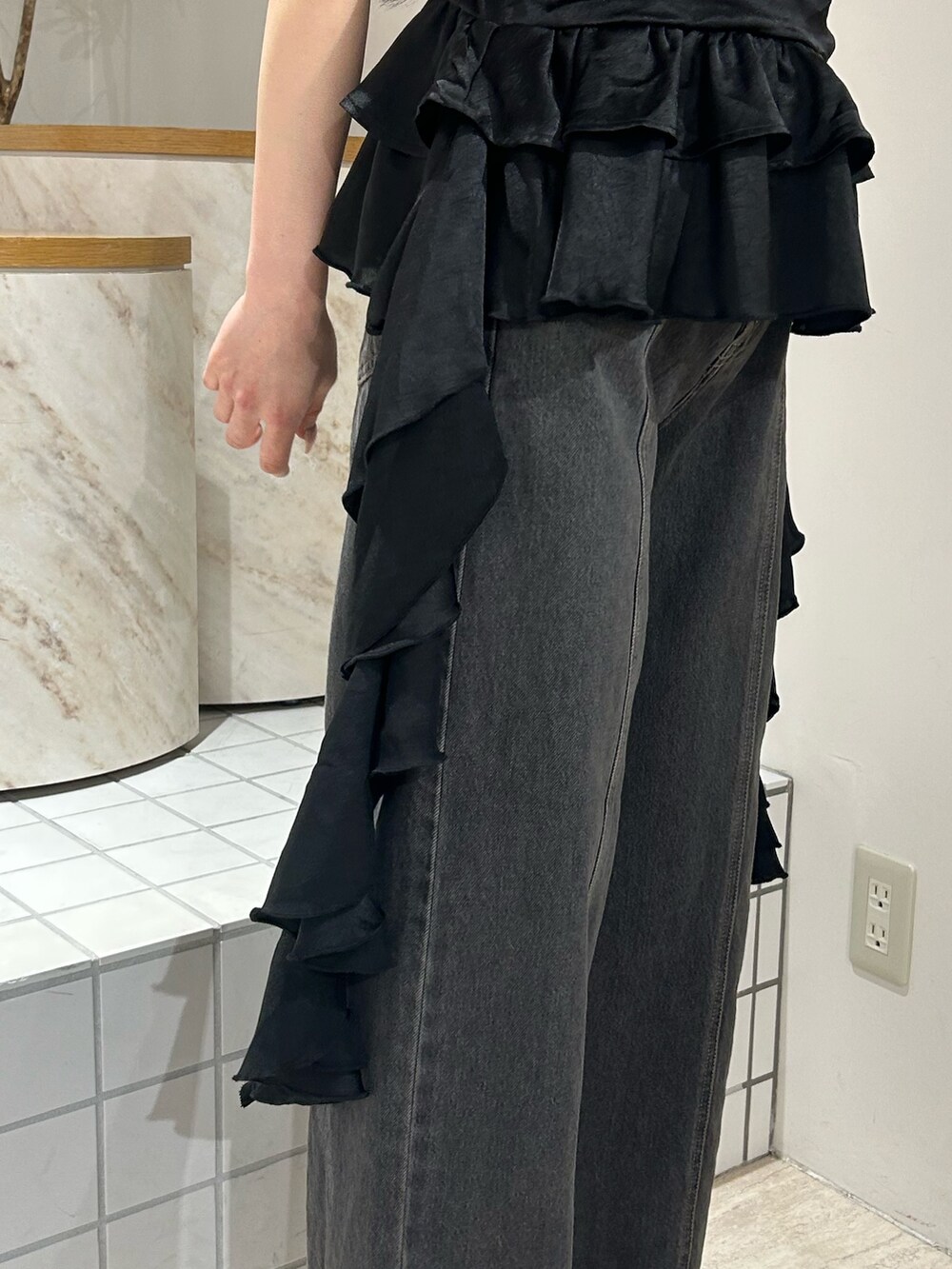 ブラック系のキャミソール、ブラック系のTシャツ/カットソー、ブラック系のデニムパンツを着用したレディースの春コーディネートの6枚目の写真