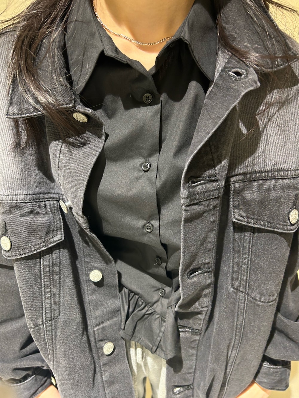 ブラック系のデニムジャケット、ブラック系のシャツ/ブラウス、グレー系のスウェットパンツを着用したレディースの春コーディネートの3枚目の写真