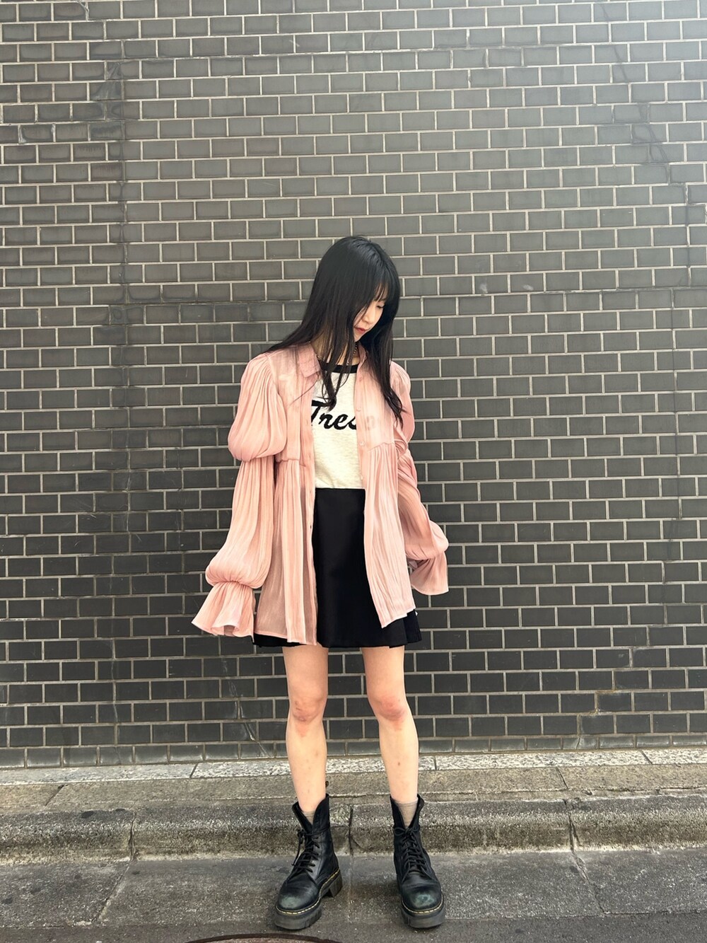 ピンク系のシャツ/ブラウス、ホワイト系のニット/セーター、ブラック系のスカートを着用したレディースの春コーディネートの2枚目の写真