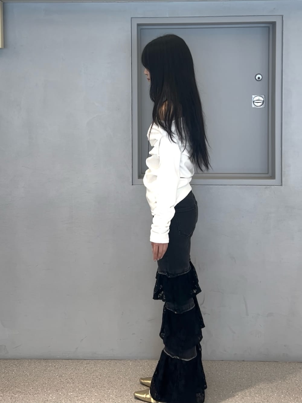 ホワイト系のTシャツ/カットソー、ブラック系のデニムパンツ、ゴールド系のパンプスを着用したレディースの春コーディネートの2枚目の写真