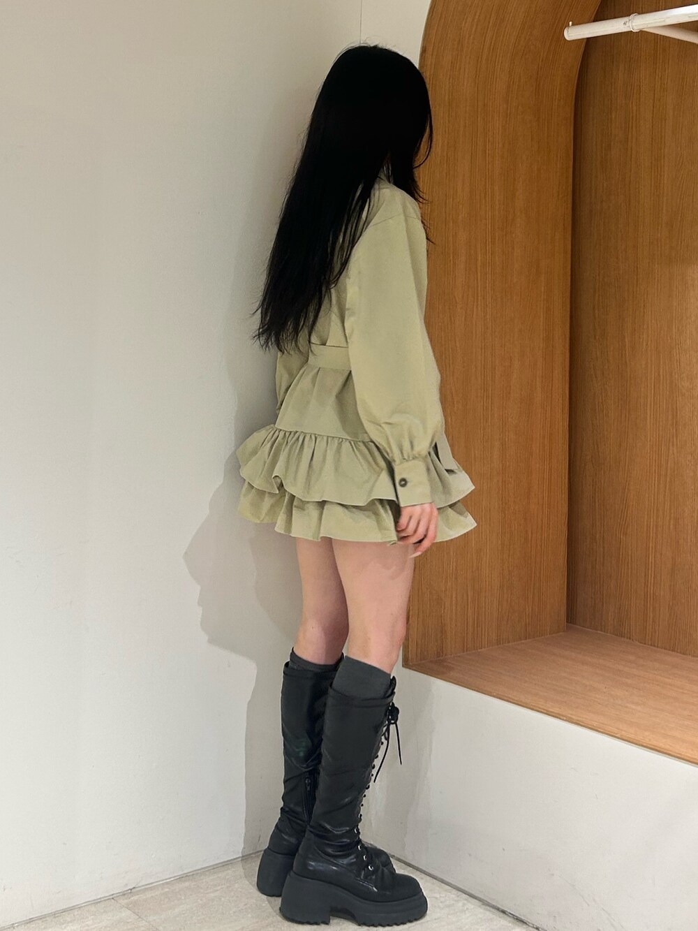 ベージュ系のワンピース、ブラック系のブーツを着用したレディースの冬コーディネートの2枚目の写真