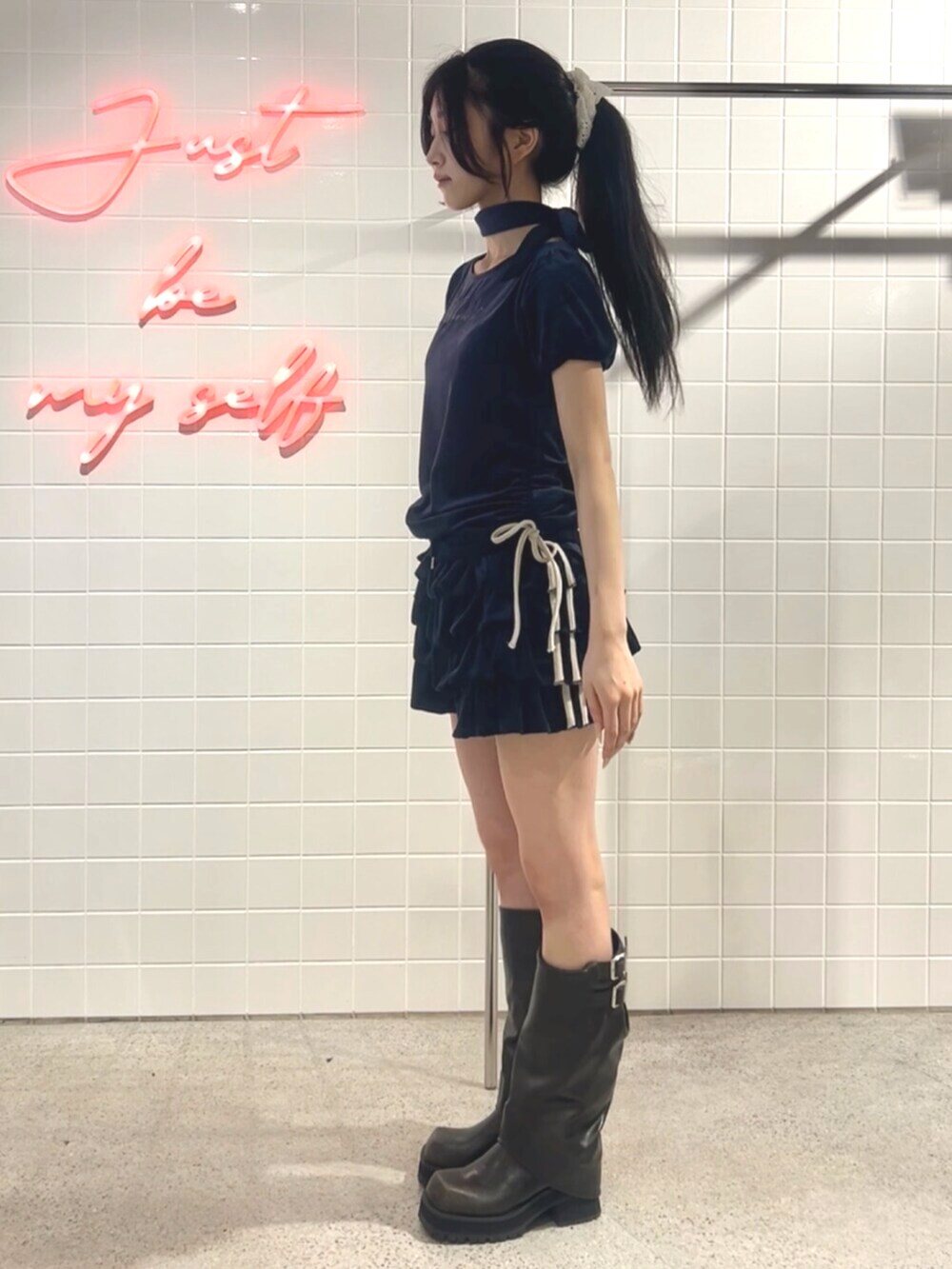 ブラック系のブーツ、ブルー系のTシャツ/カットソー、ブルー系のスカートを着用したレディースの夏コーディネートの2枚目の写真