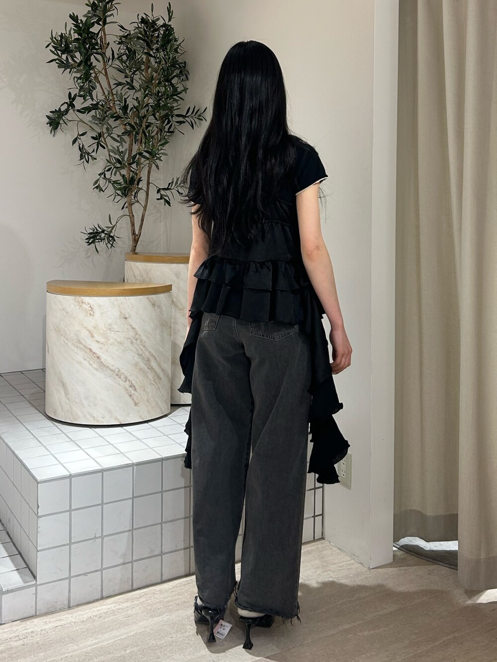 ブラック系のキャミソール、ブラック系のTシャツ/カットソー、ブラック系のデニムパンツを着用したレディースの春コーディネートの3枚目の写真