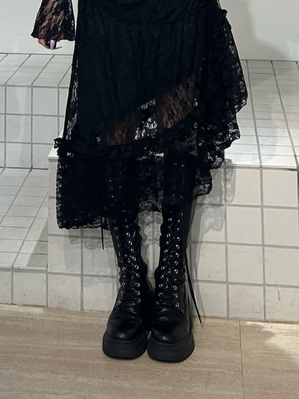 ブラック系のワンピース、ブラック系のブーツを着用したレディースの秋コーディネートの6枚目の写真