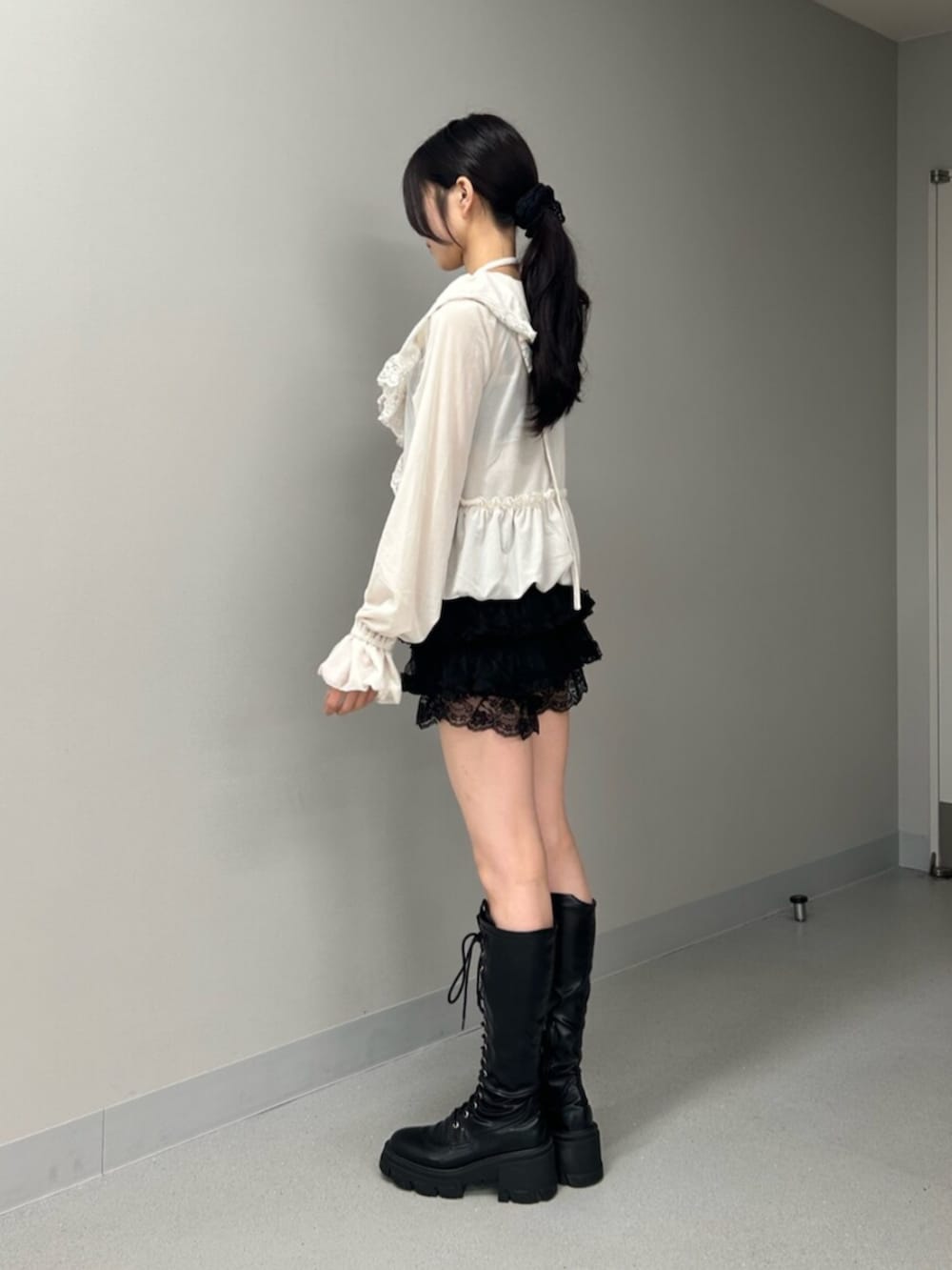 ブラック系のブーツ、ブラック系のその他パンツ、ホワイト系のシャツ/ブラウスを着用したレディースの秋コーディネートの2枚目の写真