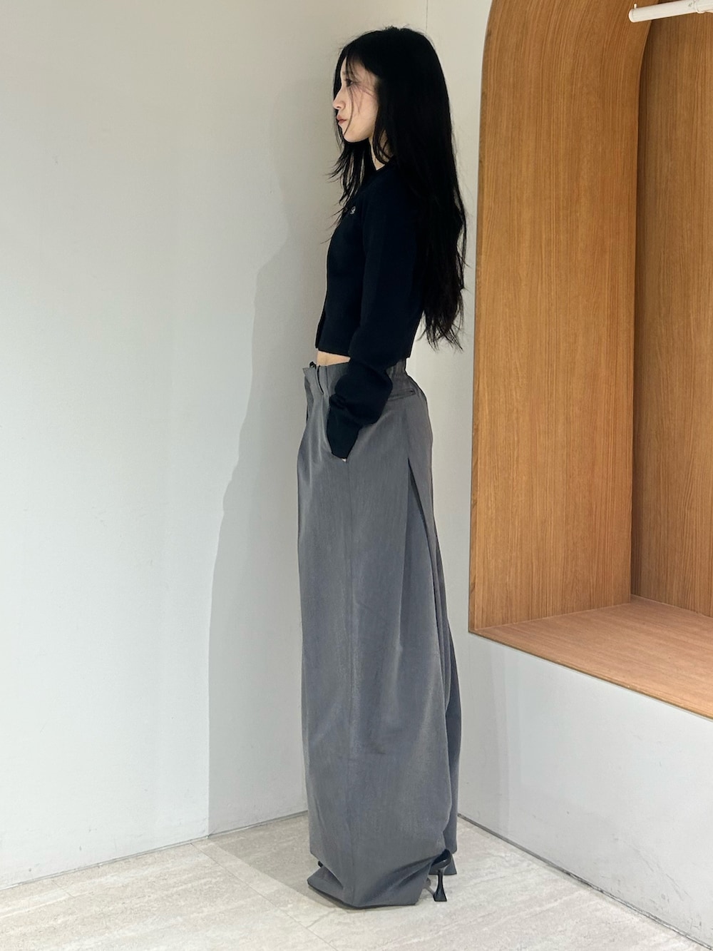 ブラック系のパンプス、グレー系のスラックス、ブラック系のカーディガン/ボレロを着用したレディースの春コーディネートの2枚目の写真