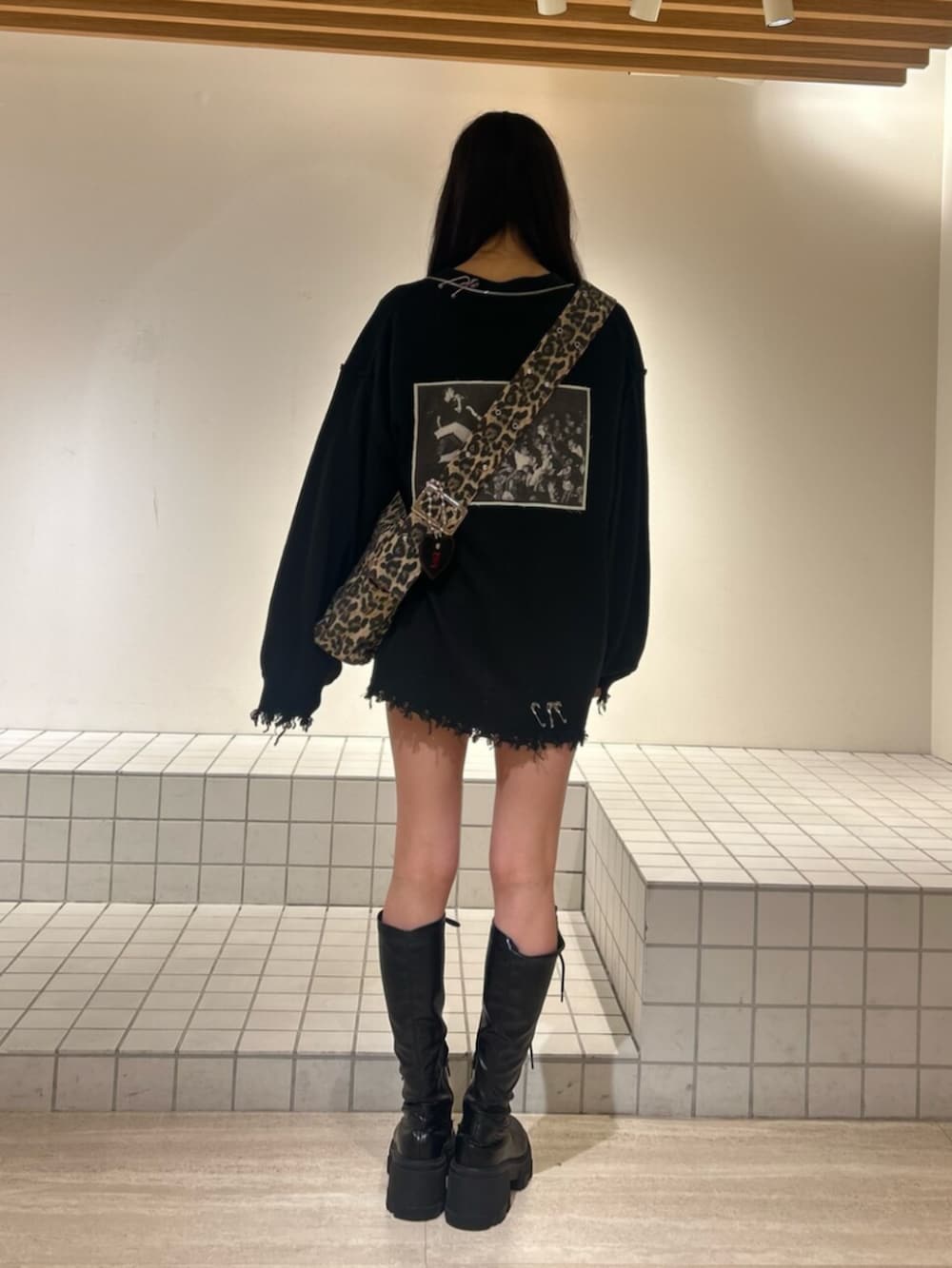 ブラック系のブーツ、ブラック系のTシャツ/カットソー、ブラック系のカーディガン/ボレロを着用したレディースの秋コーディネートの3枚目の写真
